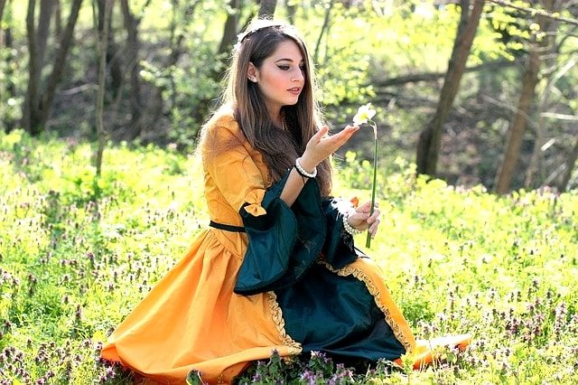 野原でタンポポを持つ美少女。