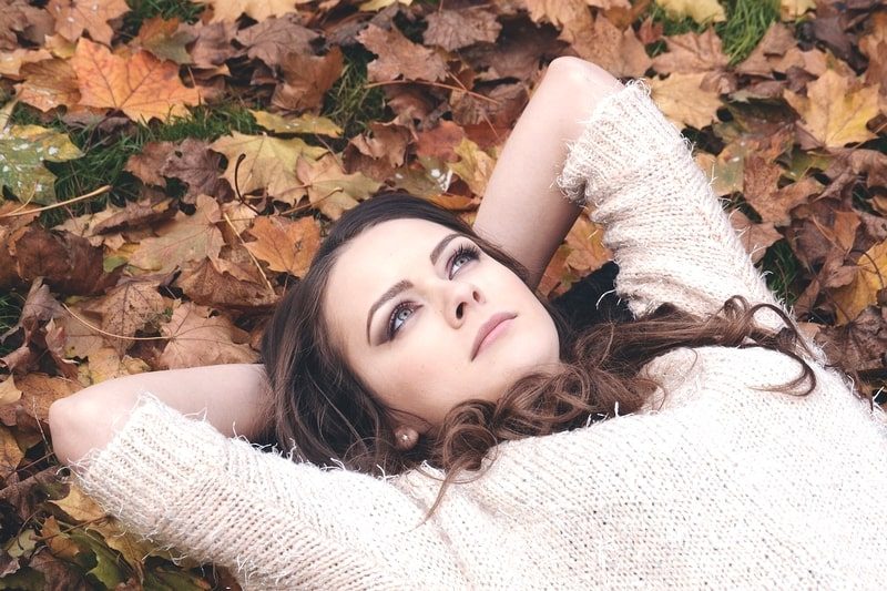 落ち葉の上に寝転る美女。