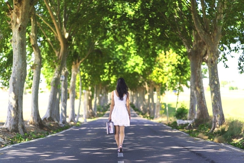 トラベルバッグを持って旅に出る美女。